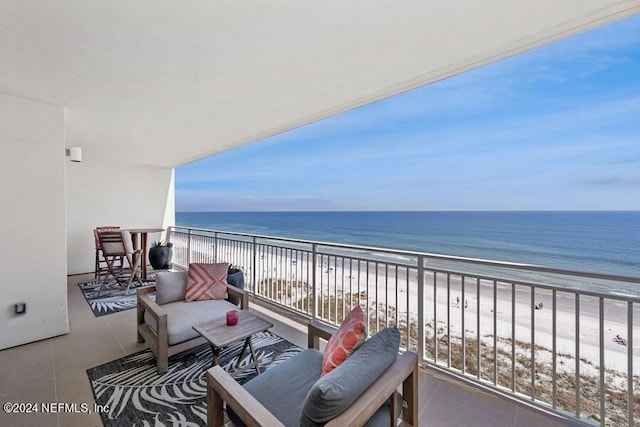 balcony with a water view and a view of the beach