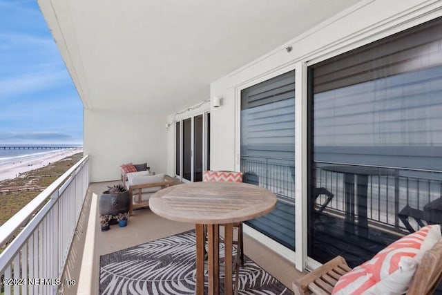 balcony featuring a water view and a view of the beach