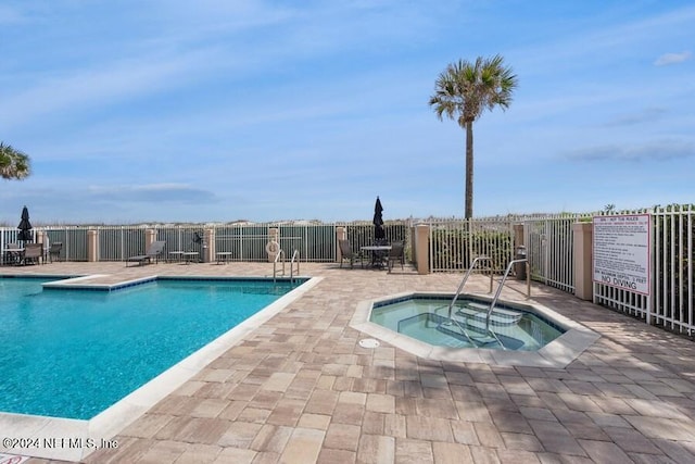 view of pool featuring a community hot tub and a patio