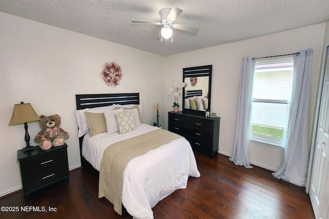 bedroom featuring multiple windows, dark wood-type flooring, a textured ceiling, and ceiling fan