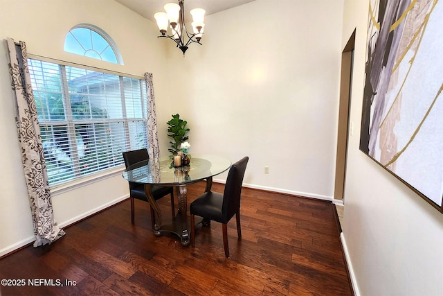 dining room with dark wood-type flooring and a notable chandelier