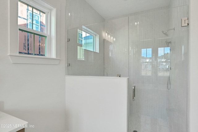 bathroom featuring a shower with shower door and vanity