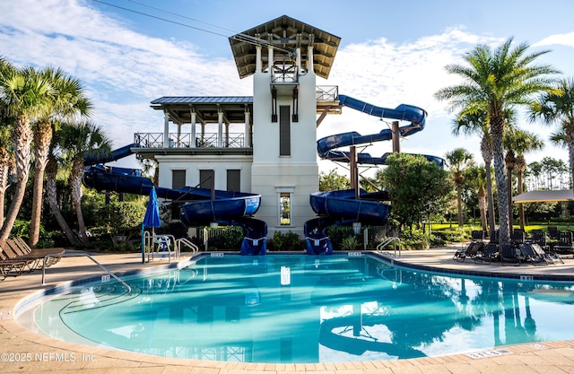 view of swimming pool with a patio area and a water slide