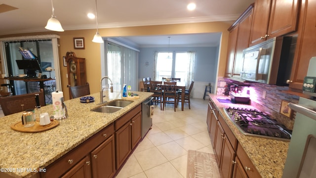 kitchen with appliances with stainless steel finishes, pendant lighting, sink, crown molding, and light stone countertops