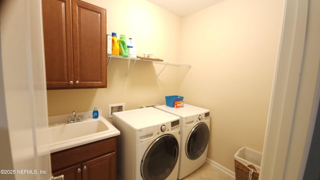 washroom with sink, light tile patterned floors, cabinets, and washing machine and clothes dryer