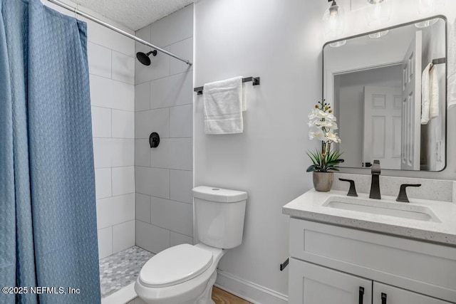 bathroom with vanity, a textured ceiling, toilet, and walk in shower