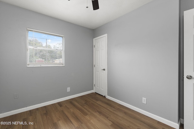 spare room with dark hardwood / wood-style flooring and ceiling fan