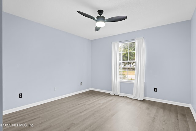 spare room featuring light hardwood / wood-style flooring and ceiling fan