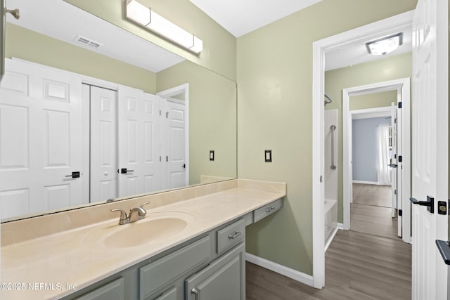 bathroom featuring vanity, wood-type flooring, and bathing tub / shower combination