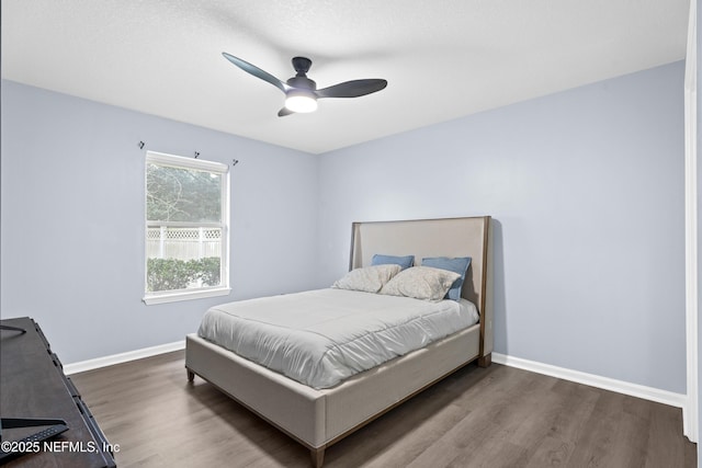 bedroom with ceiling fan and dark hardwood / wood-style floors