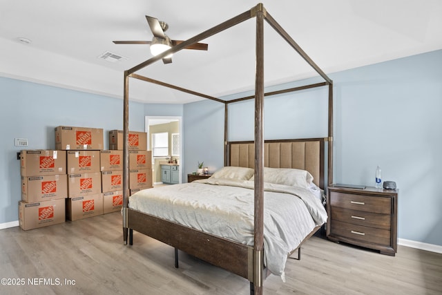 bedroom with ceiling fan, ensuite bathroom, and light hardwood / wood-style floors