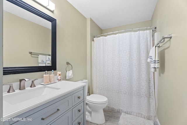 bathroom with vanity, toilet, and a textured ceiling