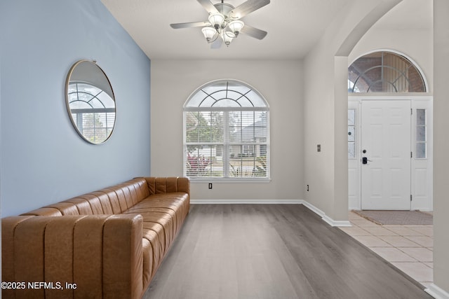 foyer entrance with ceiling fan and light wood-type flooring