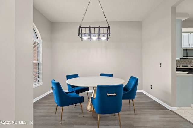 dining space with an inviting chandelier and wood-type flooring