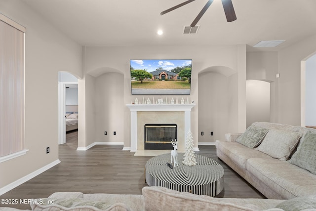 living room with hardwood / wood-style flooring, a premium fireplace, and ceiling fan