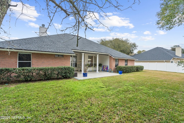 back of property with a patio and a lawn