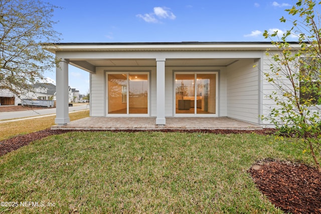 back of property featuring a yard and a patio area