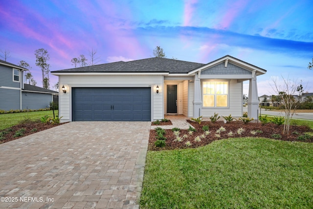 view of front of property with a garage and a lawn