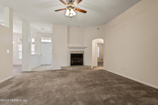 unfurnished living room featuring ceiling fan, carpet flooring, and a textured ceiling