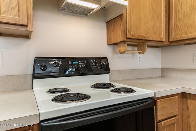 kitchen featuring black electric range oven and range hood