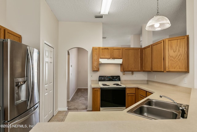 kitchen featuring stainless steel refrigerator with ice dispenser, sink, range with electric cooktop, a textured ceiling, and pendant lighting