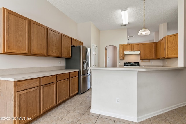 kitchen featuring hanging light fixtures, stove, a textured ceiling, and stainless steel fridge with ice dispenser