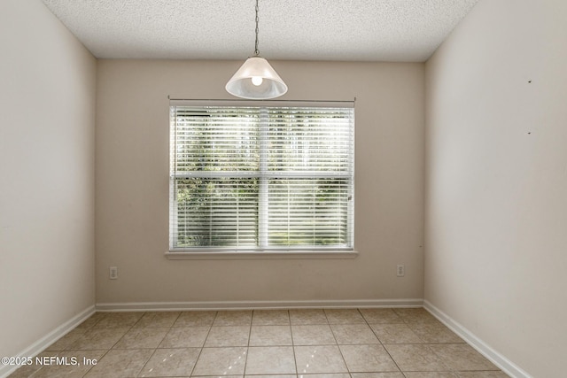 tiled spare room with a textured ceiling