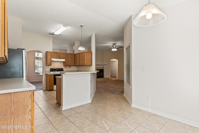 kitchen featuring light tile patterned flooring, stainless steel fridge, hanging light fixtures, electric range, and a textured ceiling