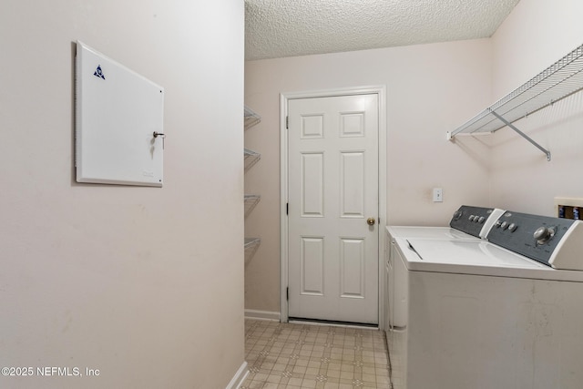 laundry area with washing machine and dryer and a textured ceiling