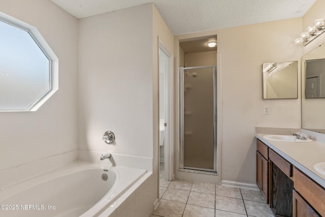 bathroom featuring vanity, tile patterned floors, a textured ceiling, and separate shower and tub