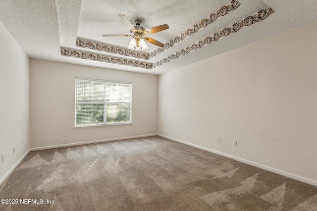 carpeted spare room featuring ceiling fan and a tray ceiling