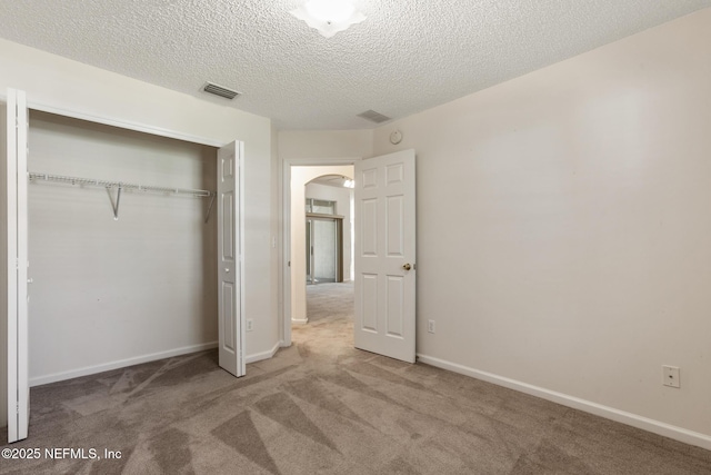 unfurnished bedroom featuring carpet floors, a textured ceiling, and a closet