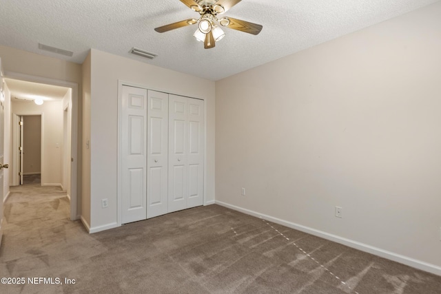 unfurnished bedroom featuring a textured ceiling, a closet, ceiling fan, and carpet