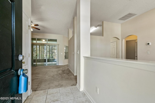 carpeted foyer with ceiling fan and a textured ceiling