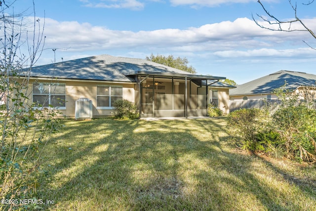 rear view of property with a yard and a sunroom