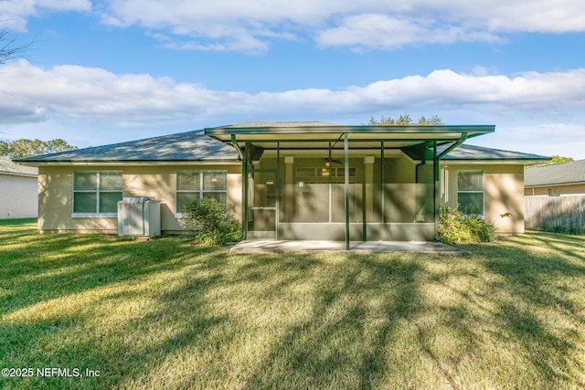 rear view of property with a yard and a sunroom