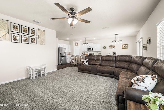 living room featuring ceiling fan and dark colored carpet