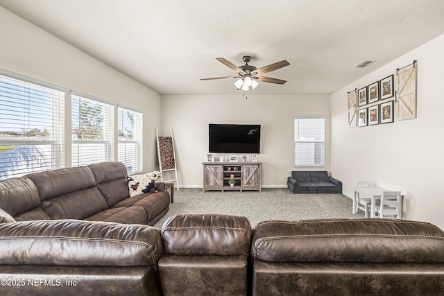 carpeted living room with ceiling fan and a textured ceiling