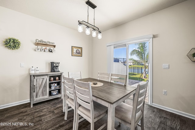 dining room with dark hardwood / wood-style floors and a water view