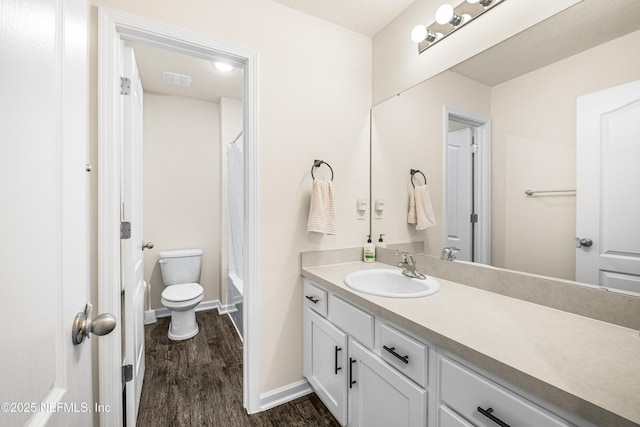 bathroom featuring hardwood / wood-style floors, toilet, vanity, and a textured ceiling