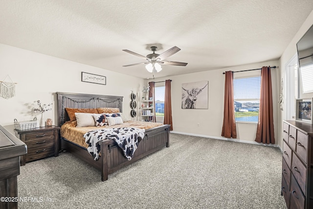 carpeted bedroom featuring ceiling fan and a textured ceiling