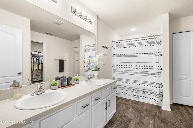 bathroom featuring walk in shower, vanity, a textured ceiling, and hardwood / wood-style flooring