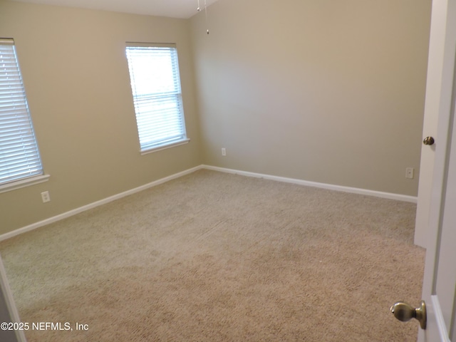 unfurnished room featuring light carpet