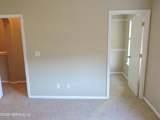 unfurnished bedroom with light carpet and a closet