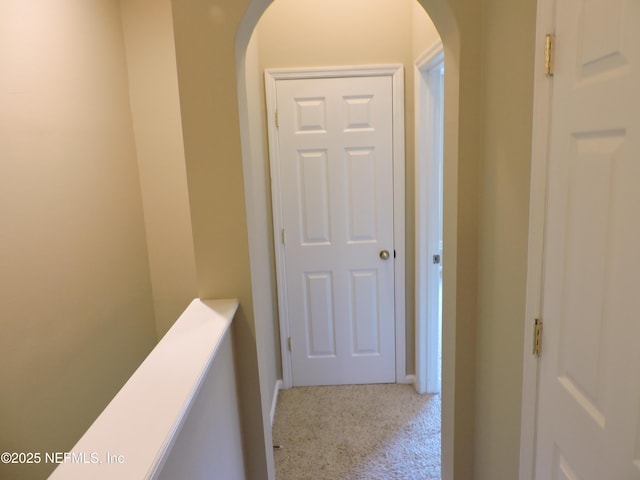 hallway featuring light colored carpet