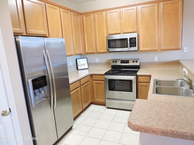 kitchen featuring light tile patterned floors, kitchen peninsula, sink, and stainless steel appliances