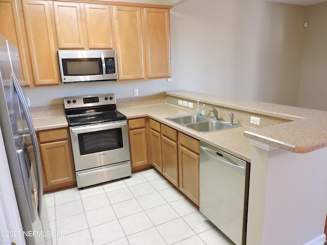 kitchen with light tile patterned floors, appliances with stainless steel finishes, kitchen peninsula, and sink