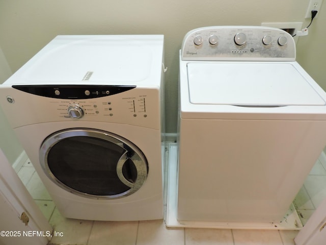 clothes washing area with independent washer and dryer and tile patterned flooring