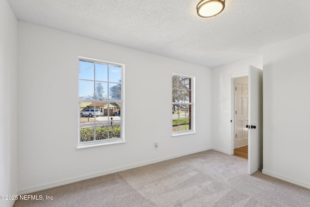 carpeted empty room featuring a textured ceiling