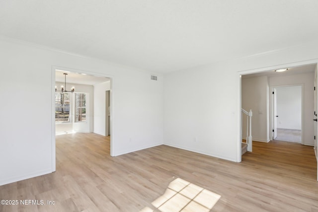 unfurnished room featuring light wood-type flooring, a notable chandelier, and ornamental molding